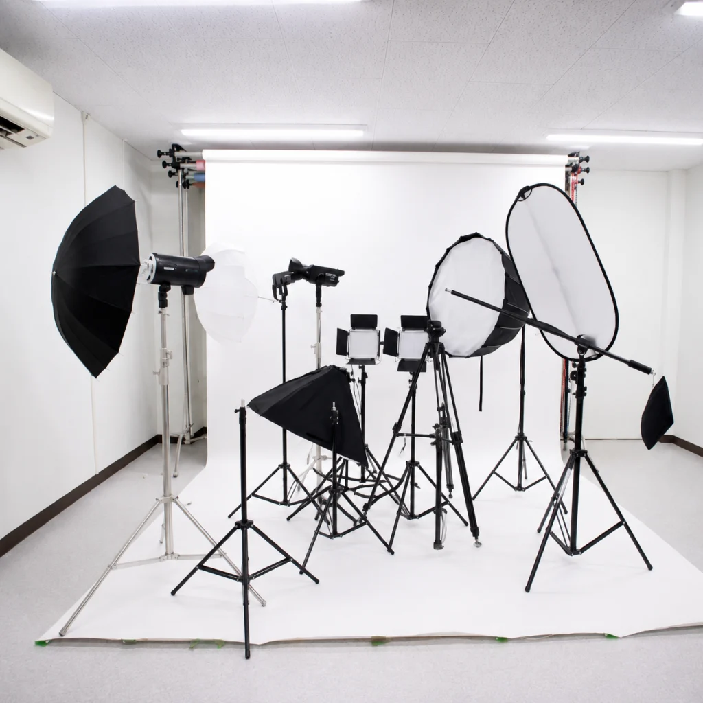 Photography studio setup with a white seamless backdrop and multiple studio lights, softboxes, and stands arranged for shooting the scene.